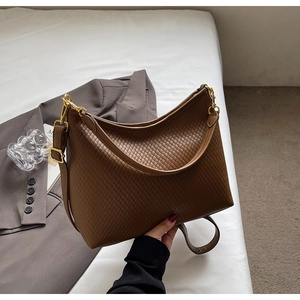 Détail d'un sac cabas marron texturé avec garnitures dorées et deux bandoulières