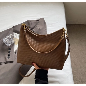 Gros plan sur le tissage caramel et les finitions dorées de ce grand sac cabas