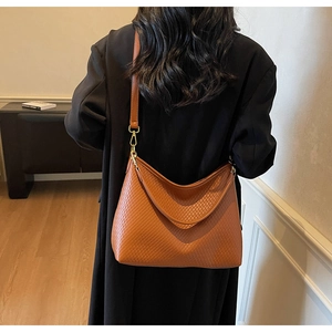 Détail du sac cabas marron caramel avec motif matelassé et accessoires métalliques
