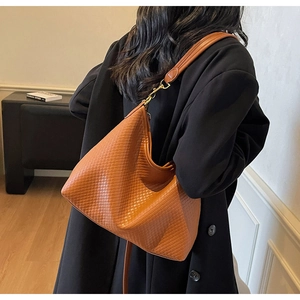 Détail du grand sac cabas tissé beige avec quincaillerie dorée à l'épaule