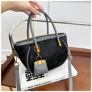 Chic black velvet bucket bag with grey leather handles and gold hardware detail
