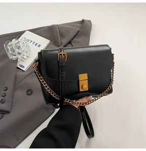 Vue détaillée du petit sac carré en cuir noir avec fermoir métallique doré de luxe