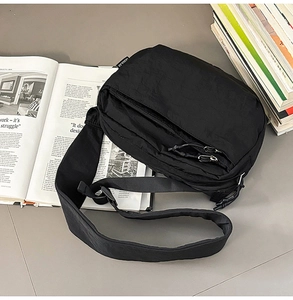 Close-up of black nylon crossbody bag with multi-pocket design and adjustable strap