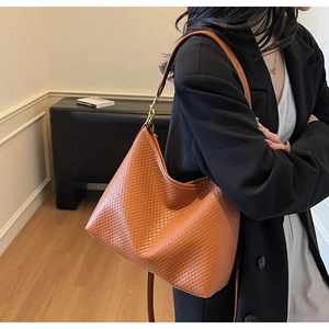 Sac hobo marron à texture tressée porté par un mannequin pour un style quotidien