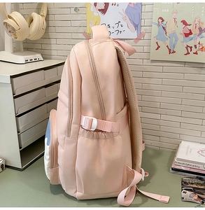 Side view of pink student backpack showing compression straps and side mesh pockets