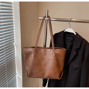 Detailed view of vintage brown tote bag texture and elegant pleating on the bottom