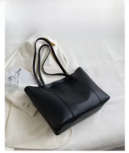 Détail du sac cabas minimaliste en cuir PU noir avec une élégante couture décorative en V