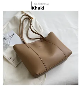 Détail d'un sac cabas kaki minimaliste sur tissu blanc avec décor pour le quotidien