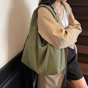 Sac à bandoulière hobo en velours côtelé vert olive dans un cadre lifestyle élégant