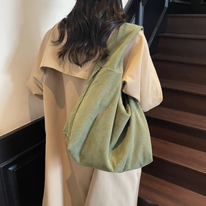 Détail d'un sac bandoulière en velours côtelé vert foncé avec texture verticale