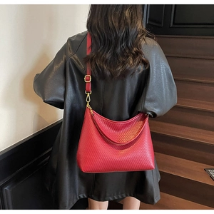 Détail du sac hobo rouge à motif de losanges gaufrés et finitions métalliques dorées