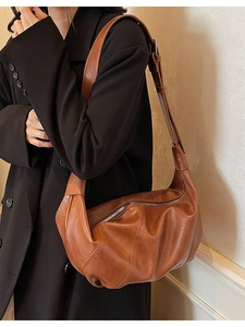 Brown textured PU leather crescent moon hobo bag with wide strap on shoulder