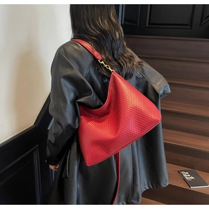 Grand sac hobo rouge avec texture matelassée en losanges porté par un mannequin en studio