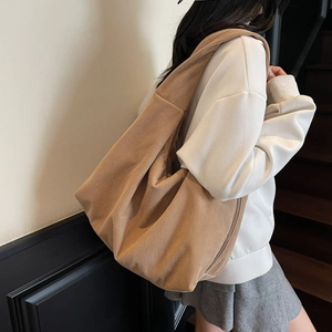 Gros plan sur la texture du grand sac hobo en velours côtelé kaki à bandoulière