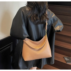 Détail du sac fourre-tout beige tissé avec bandoulière en cuir et boucle dorée