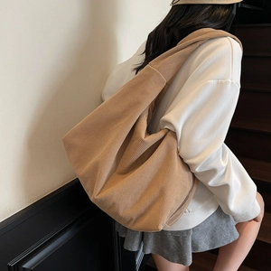Gros plan d'un sac cabas en velours côtelé kaki avec large bandoulière sur l'épaule