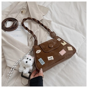 Detalles del bolso de hombro en pana marrón con bordados y colgante de perro peluche