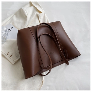 Détail d'un grand sac cabas marron foncé avec imprimé Fashion Items et anses d'épaule