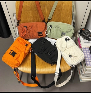 Five stylish crossbody bags in various colors on a vintage chair with textured fabric