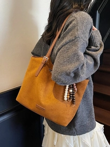 Brown faux suede tote bag with wooden bead charm and adjustable strap for daily use