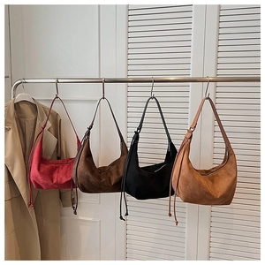 Hanging display of retro hobo bags in matte suede finish with drawstring detail