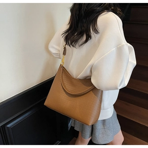 Détail du sac hobo tressé marron caramel avec ferrures dorées et bandoulière en cuir