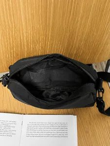 Detailed macro view showing the internal compartment and slip pocket of the black bag
