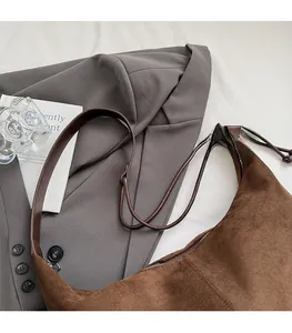 Detailed view of brown suede tote bag with slim shoulder strap and zipper closure