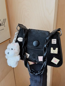 Bolso tipo cubo minimalista negro mate con bordados vintage y un dije de perro de peluche