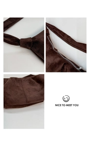 Detail view of dark brown suede crossbody bag with knotted strap and metal zipper
