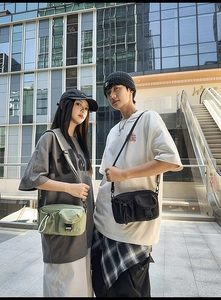 Detailed view of urban nylon crossbody bags in sage green and black with multiple pockets
