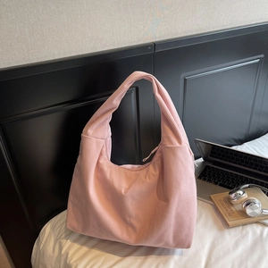 Vue détaillée du sac en velours côtelé rose avec mise en avant du tissu et de la bandoulière