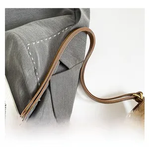Detail shot of brown suede shoulder bag strap with premium gold metal adjustment buckle