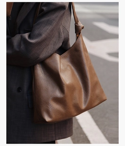 Detail of deep brown PU leather tote with knot shoulder strap and wrinkled texture