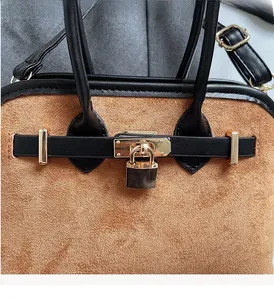 Détail du fermoir doré et du cadenas sur le sac fourre-tout en daim bicolore