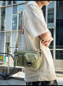 Detailed view of the olive green nylon crossbody bag with functional multi-pockets