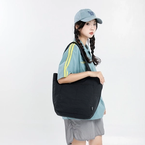 Vue latérale du grand sac cabas en nylon noir porté par un mannequin pour le quotidien