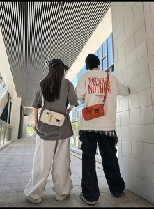 Detail of trendy crossbody messenger bag in cream and orange with adjustable strap