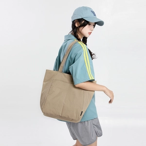 Détail du sac fourre-tout kaki avec deux grandes poches avant et étiquette tissée latérale