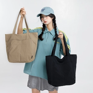 Détail des grands sacs cabas en nylon kaki et noir pour les trajets quotidiens et étudiantes