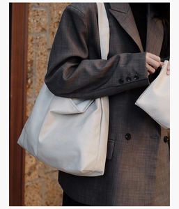Detail view of large beige tote bag set including a matching small zipper pouch