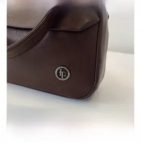 Detailed close-up of the vintage brown leather bag featuring an antique metal LF logo buckle