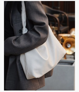 Close-up of white oversized tote bag with soft leather texture and stylish knot strap detail