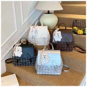 Detailed display of fashionable backpacks in multiple colors with dog charms on stairs