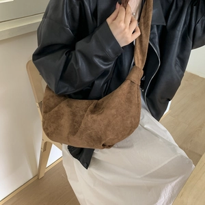 Detail of vintage caramel brown suede crossbody bag featuring a unique knotted wide strap