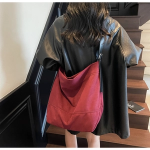 Grand sac hobo bordeaux en toile avec bandoulière réglable en cuir porté à l'épaule