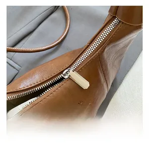 Gros plan du sac en cuir marron texturé avec fermeture éclair en métal argenté de qualité
