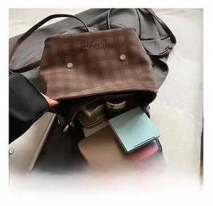 Internal storage view of brown checkered backpack with phone and cosmetics