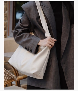 Detail of minimalist cream large capacity tote bag with stylish knotted shoulder strap
