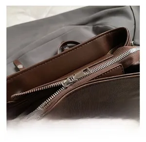 Macro detail of brown leather backpack featuring a silver metal zipper and fine stitching